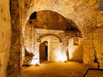 I gradoni ci conducono a 6 metri di profondit� in un ambiente scavato nella roccia calcerenitica, con al centro un sontuoso arco finemente decorato che ci lascia incantati